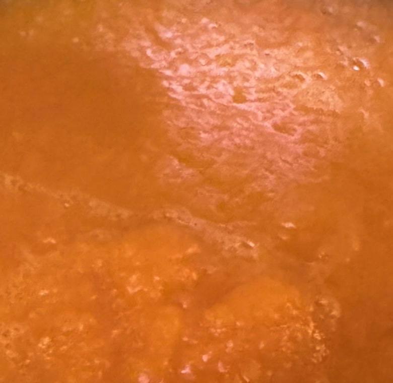 Close-up of smooth, bright orange carrot soup in a pot